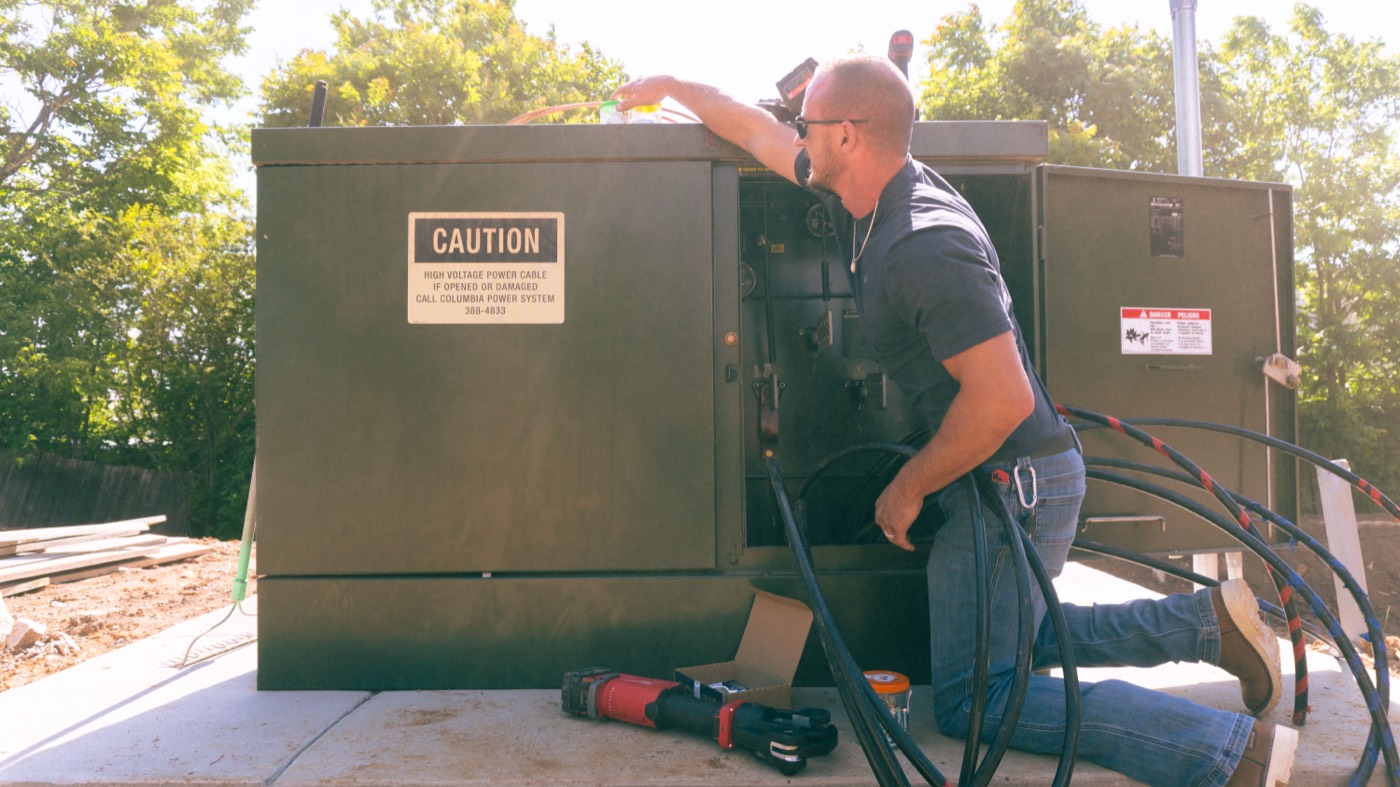 Electrician servicing outdoor switchgear